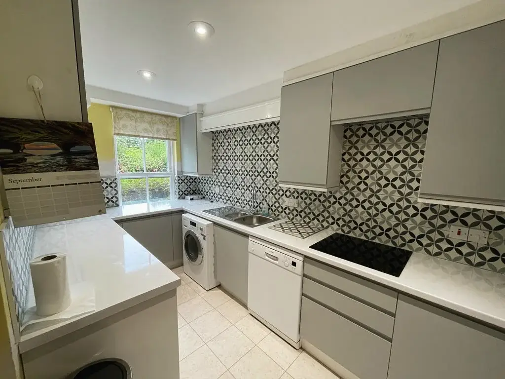 Kitchen renovation with grey units and patterned splashback tiles