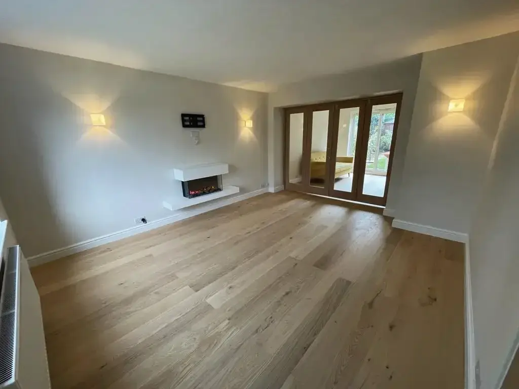 Renovated living room with oak flooring, wall lights and glazed oak doors