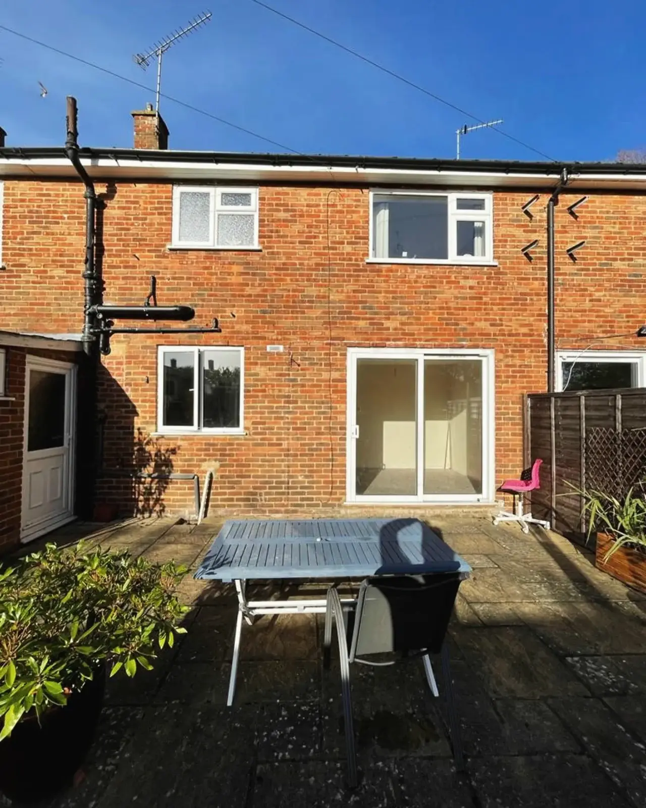 Rear of a brick house before renovation, with a small patio door