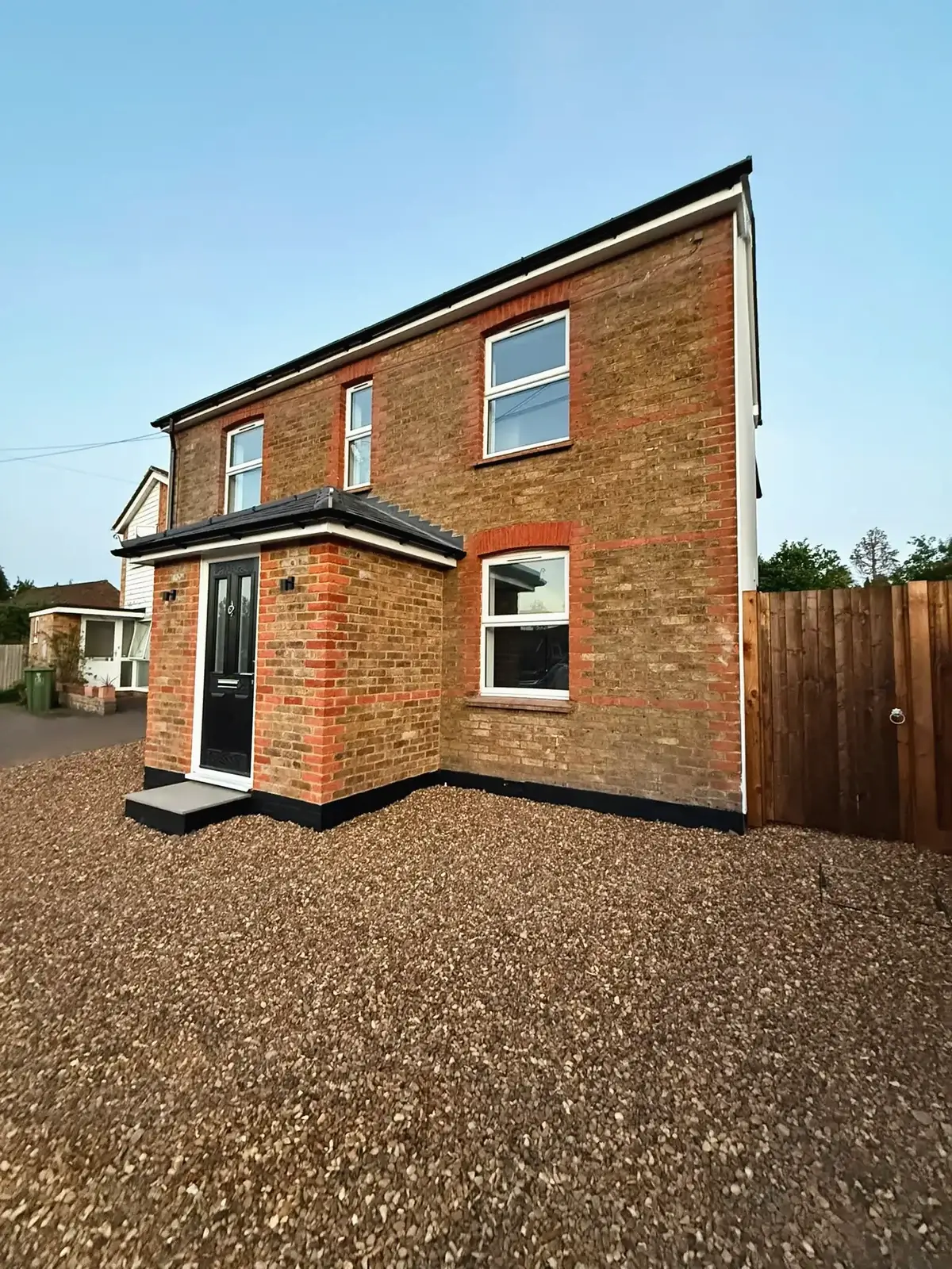 Brick house after a full renovation, with a new porch and windows